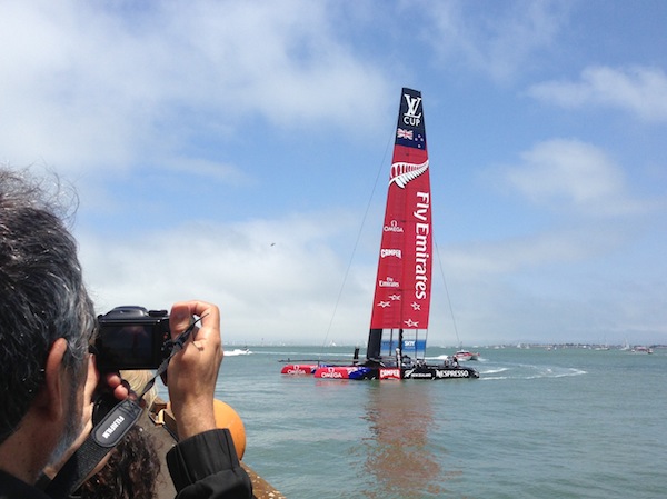 emirates team new zealand doing a flyby at america's cup park